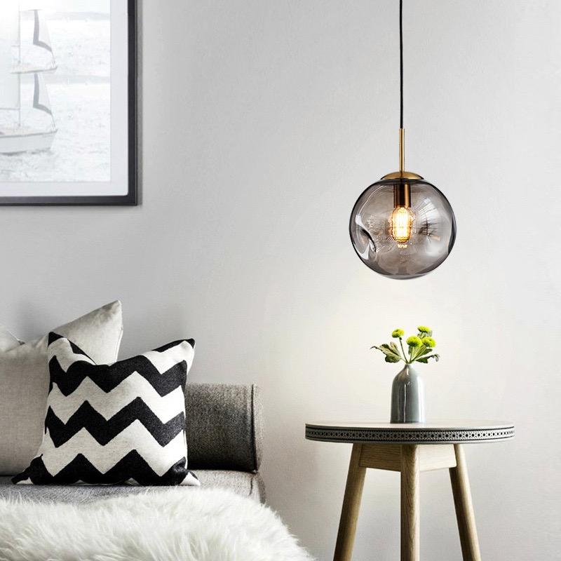 "Elegant sfærisk glasspendellampe med gullfinish, nordisk design, jevn lysfordeling, passer for moderne innemiljøer."
