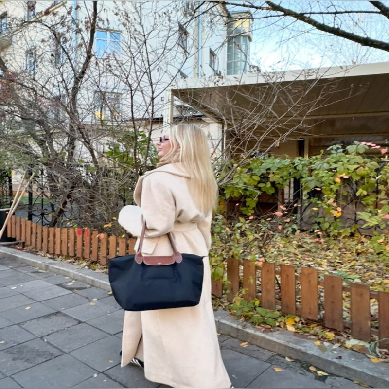 Elegant svart shopper-veske i PU-skinn for kvinner, stående oppreist og viser solid design