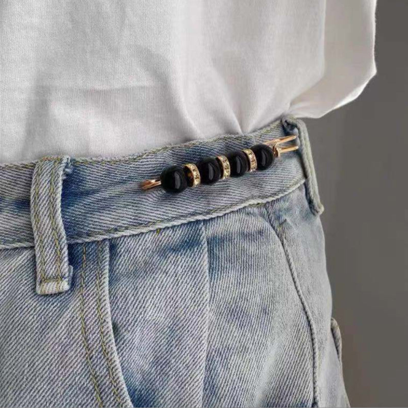 "Elegant sikkerhetsnålsbrosje med perler og rhinestones, perfekt for kjoler og skjerf, i svart og hvitt."