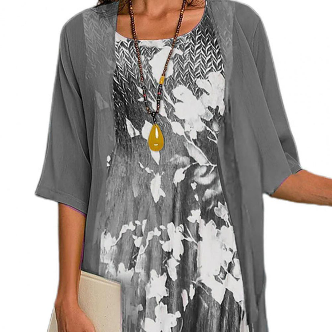 Elegant sommerkjole med blomsterprint, elastisk stoff, rund hals, feminin passform, ideell for varme sommerdager.