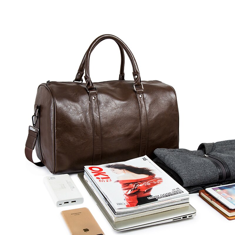 Svart duffelbag i skinn, nærbilde av logo eller merke, fremhever den elegante kvaliteten og praktiske designen.