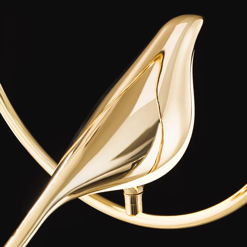 "Elegant taklampe med gylne fugler i justerbar design; metallisk finish, lyseffekt gir luksuriøs atmosfære."