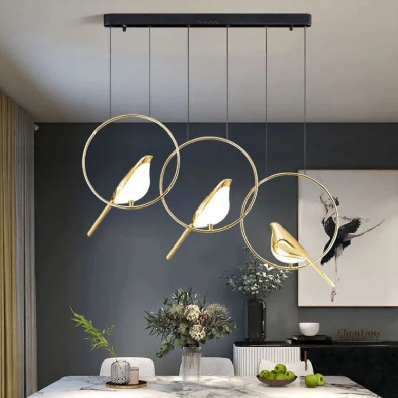 "Elegant taklampe med gylne fugler i justerbar design; metallisk finish, lyseffekt gir luksuriøs atmosfære."
