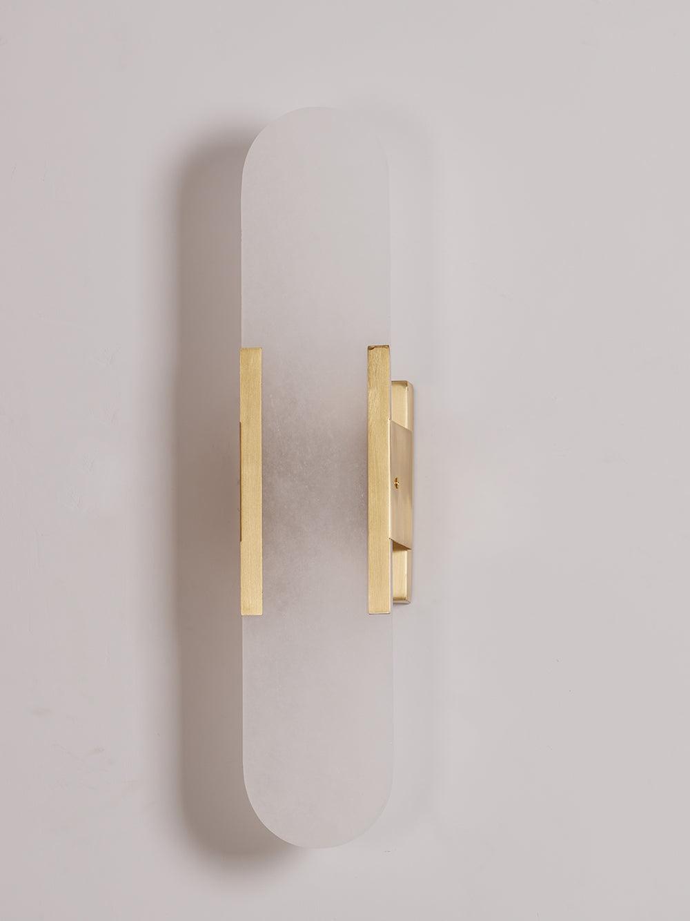 "Elegant vegglampe avlang i alabast med messingdetaljer, ideell for moderne interiør med tidløs skjønnhet og stil."