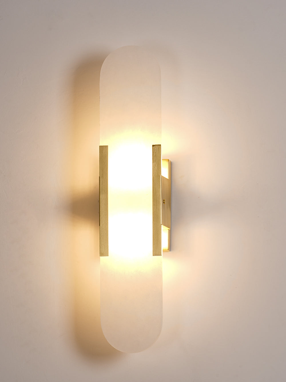 "Elegant vegglampe avlang i alabast med messingdetaljer, ideell for moderne interiør med tidløs skjønnhet og stil."