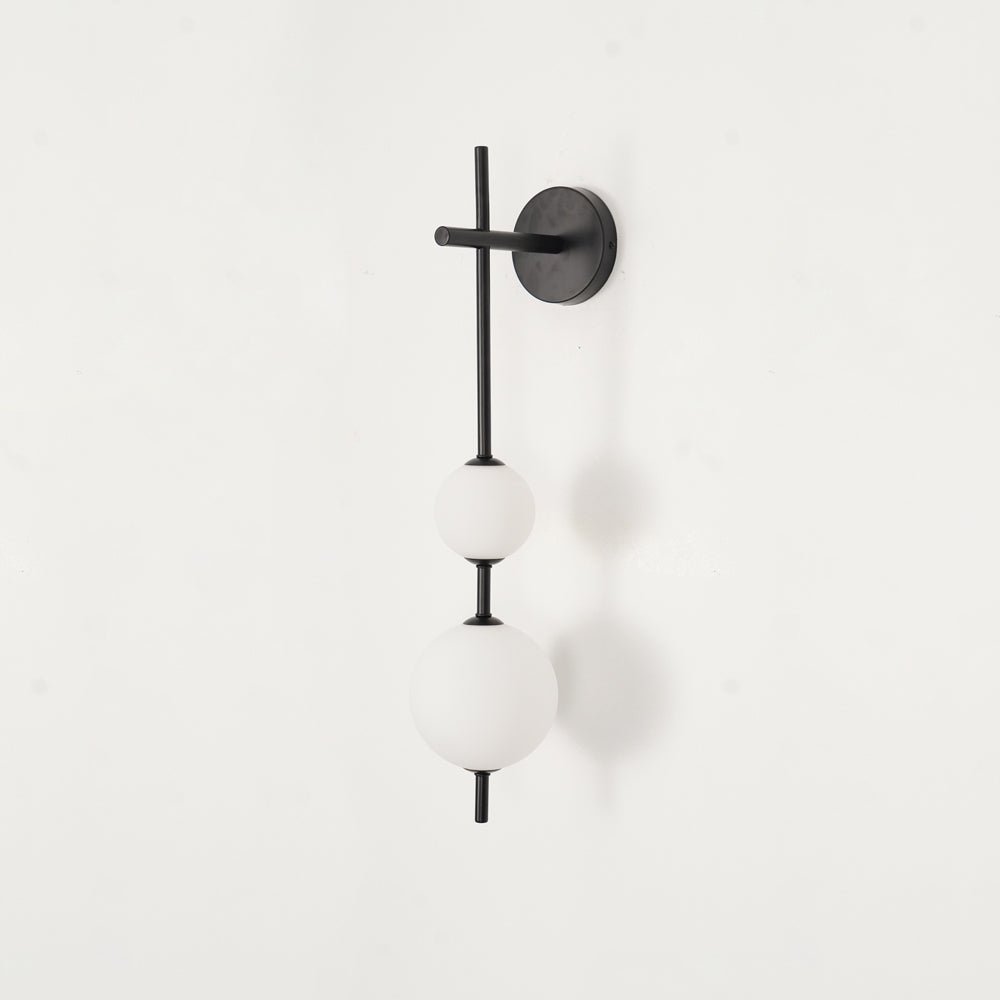 "Elegant vegglampe i glass og messing med kuleformede skjermer for mykt lys, perfekt for moderne og klassiske hjem."