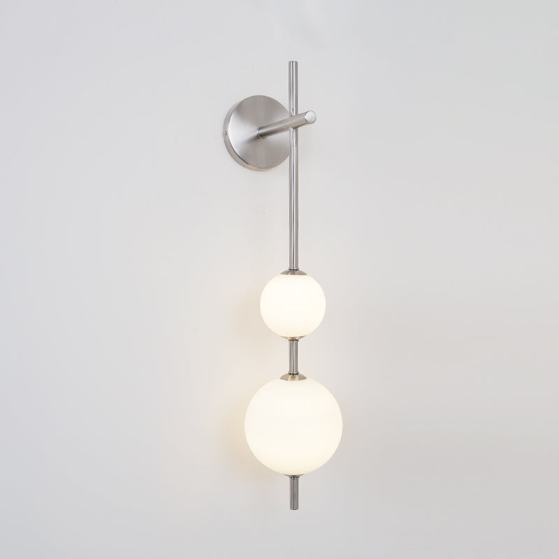 "Elegant vegglampe i glass og messing med kuleformede skjermer for mykt lys, perfekt for moderne og klassiske hjem."