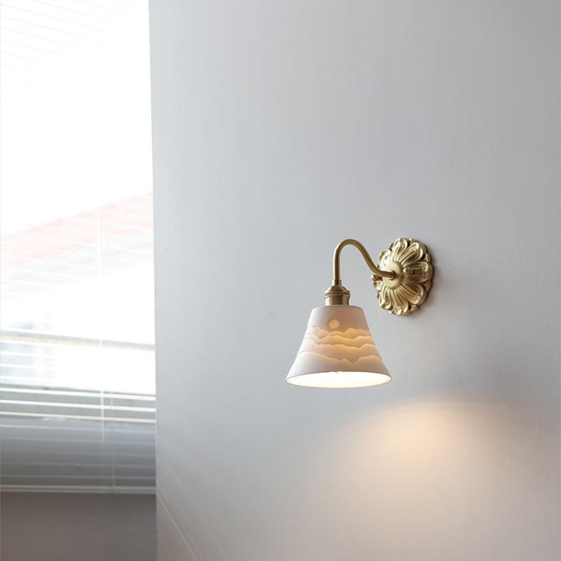 "Elegant vegglampe i messing og keramikk med antikk finish og hvit lampeskjerm, gir klassisk preg til interiøret."