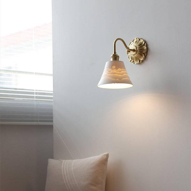 "Elegant vegglampe i messing og keramikk med antikk finish og hvit lampeskjerm, gir klassisk preg til interiøret."