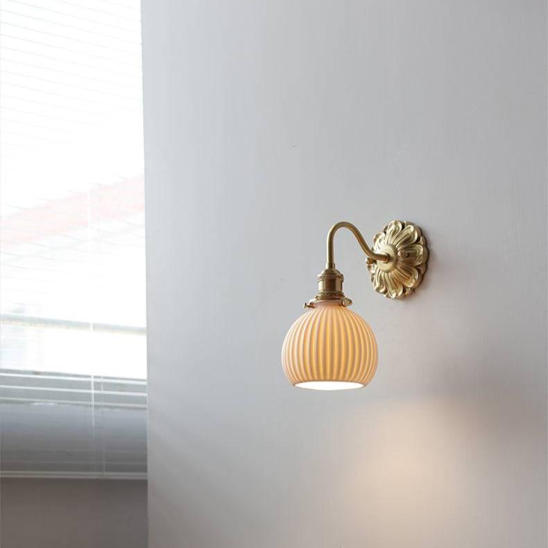 "Elegant vegglampe i messing og keramikk med antikk finish og hvit lampeskjerm, gir klassisk preg til interiøret."