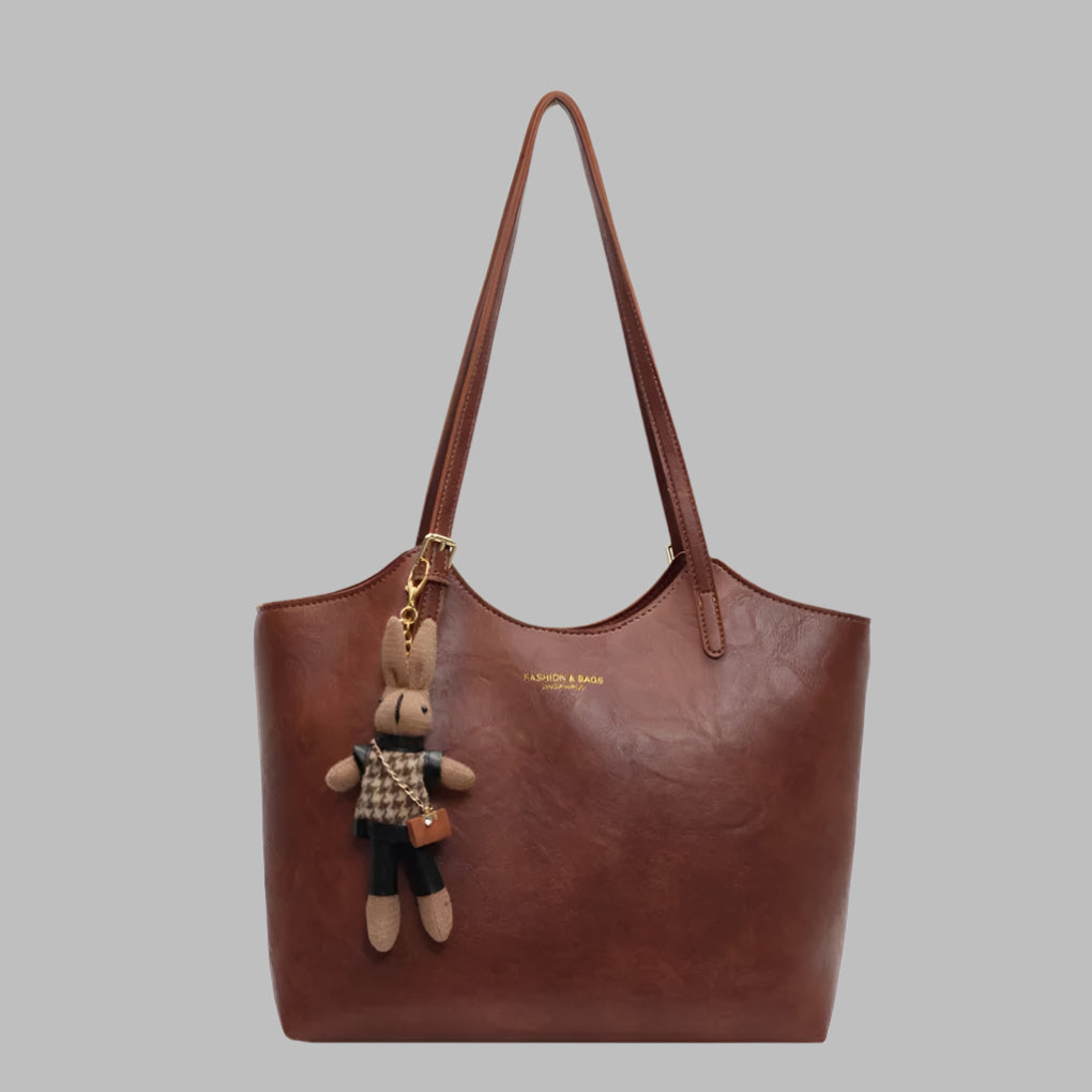 "Elegant vintage skulderveske i mykt, oljevokset skinn med rik kaffebrun farge og romslig interiør for kvinner."