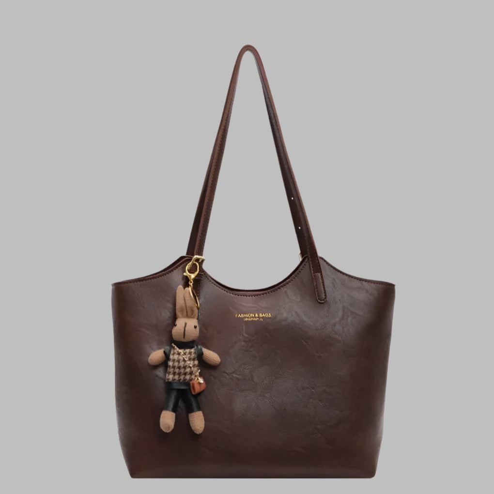 "Elegant vintage skulderveske i mykt, oljevokset skinn med rik kaffebrun farge og romslig interiør for kvinner."