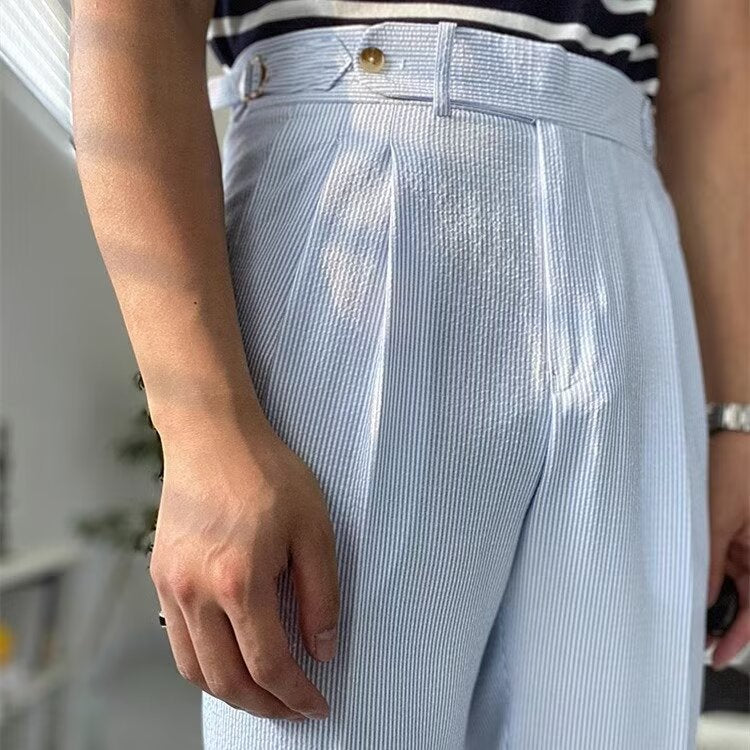 Modell iført stilige herrebukser med høy midje, straight-leg og plissert front, viser en slank og elegant passform.