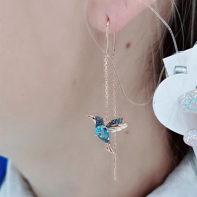 Detaljert bilde av kolibri dråpeøreringer for kvinner. Glitrende cubiczirconia smykker, elegant tilbehør.