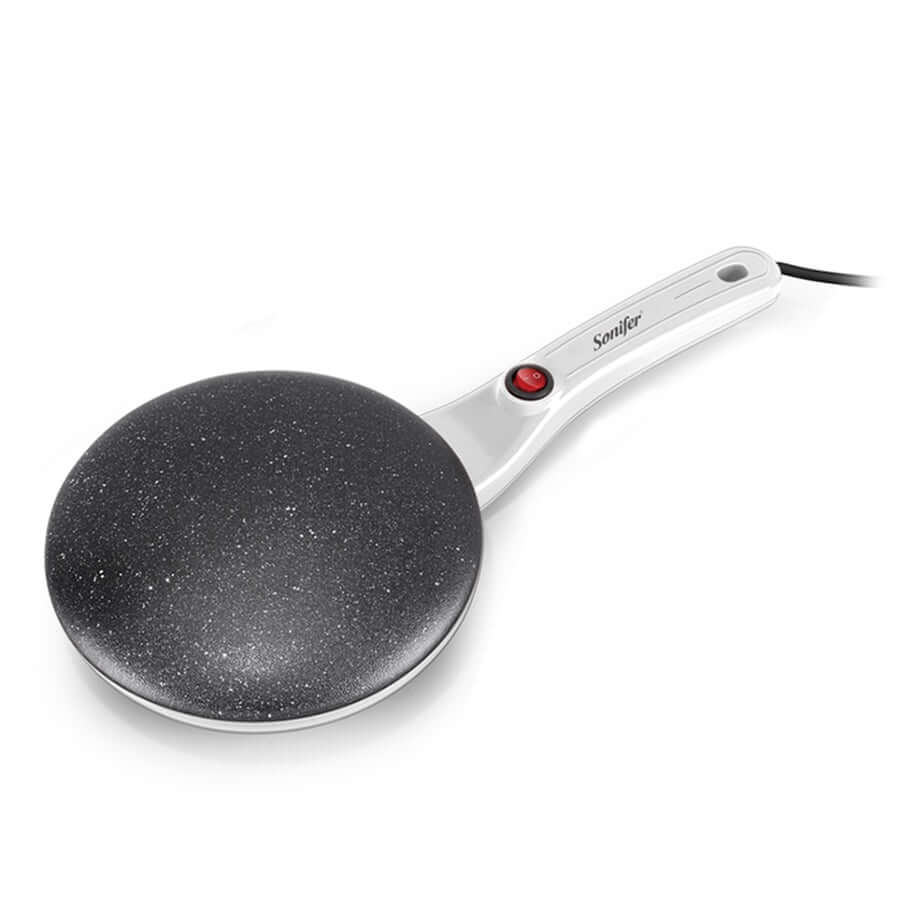 Bilde av en ferdig crêpe brettet og garnert, i forkant av den elektriske crêpe makeren.