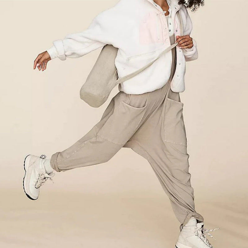 "Enkel jumpsuit med V-hals i ensfarget design, avslappet passform, racerback-stil, og lommer for praktisk bruk."