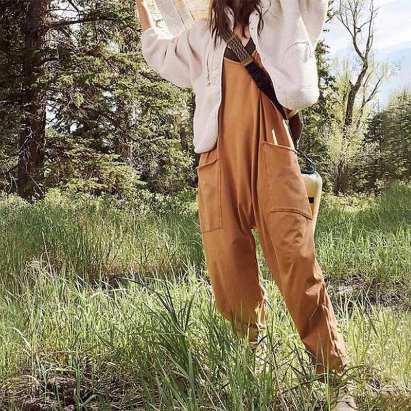 "Enkel jumpsuit med V-hals i ensfarget design, avslappet passform, racerback-stil, og lommer for praktisk bruk."