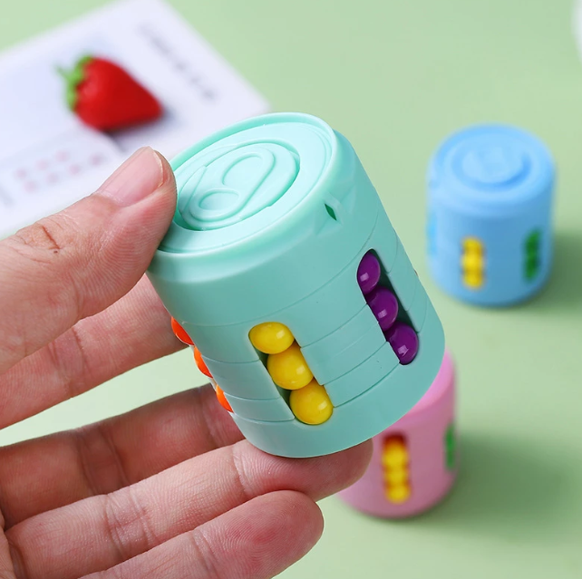 Hånd som holder en fargerik bønneboks, portabel stressleke for barn og voksne med angst