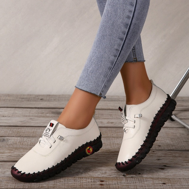 Damefot i en brun skinn loafer, viser komfortabel passform og støttende design.