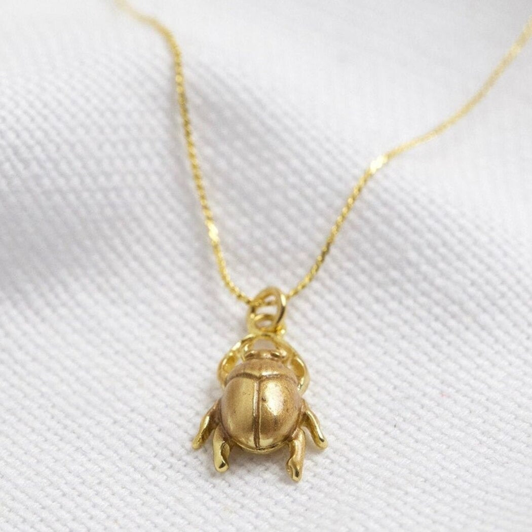 Detaljert bilde av et minimalistisk bille amulett halskjede, perfekt lykkesymbol og tilbehør.
