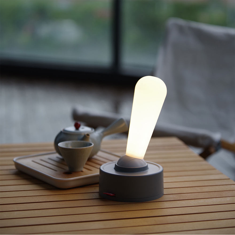 Grå og hvit bordlampe med retro spakbryter, LED-teknologi, oppladbar for fleksibel bruk, stilren minimalistisk design.