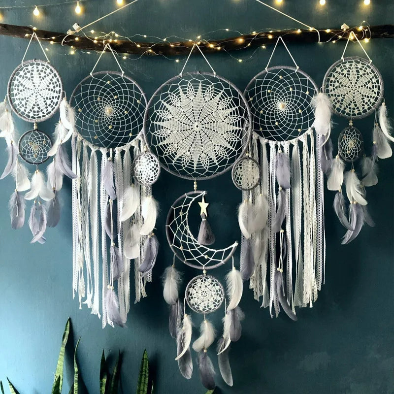 Detalj av hvit drømmefanger med heklede detaljer og myke fjær, ideell for et hjem med boho-stil.