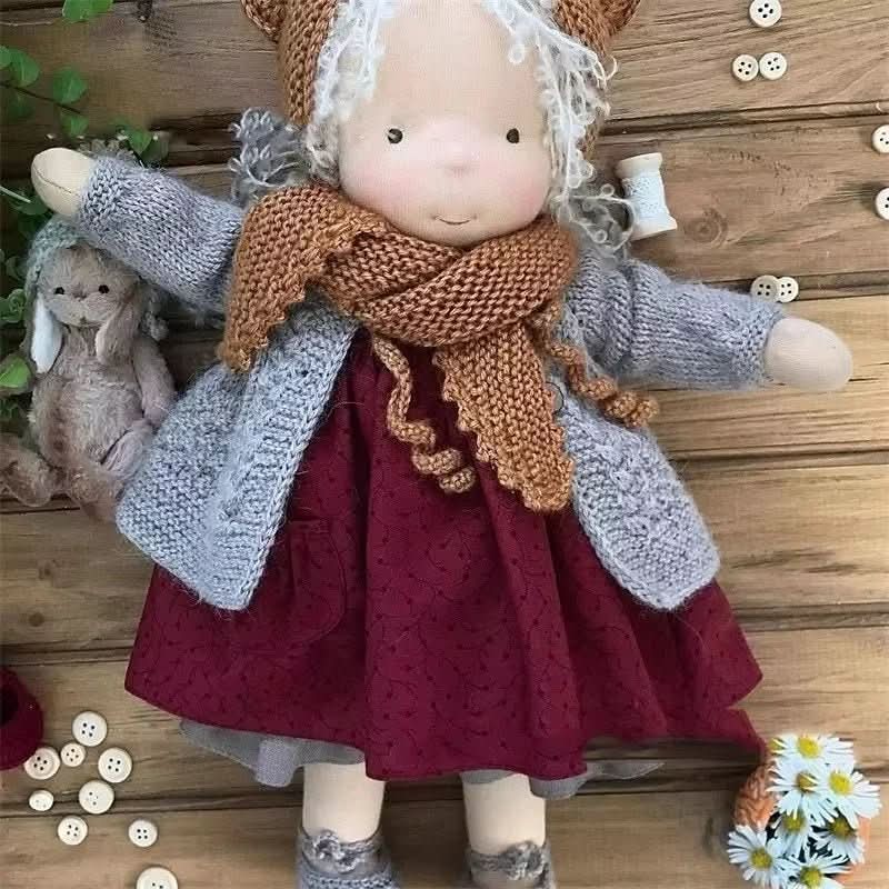 Myk håndlaget Waldorf-dukke i et lekent antrekk, en trygg og stimulerende leke for barn.