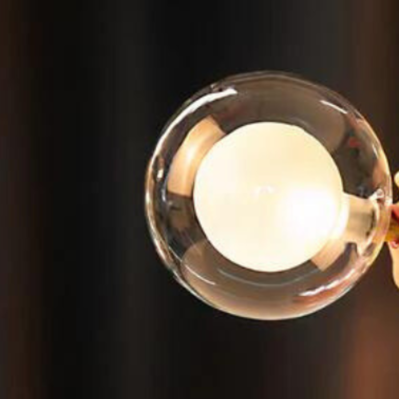 "Håndlaget bordlampe i kunstharpiks og glass med varm tre-sokkel og elegant tekstil-lampeskjerm."