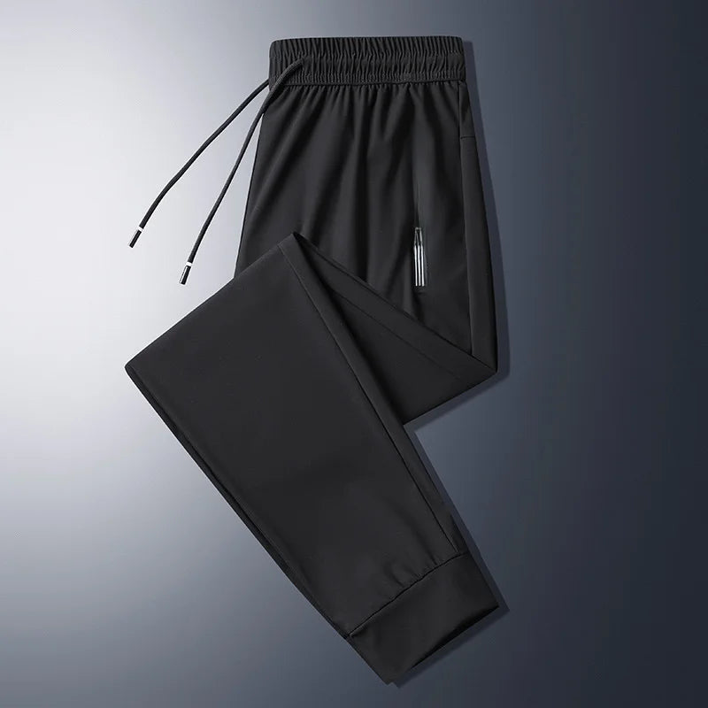Stilig herre joggebukse i mørk farge, med sporty detaljer og glidelåslommer, perfekt for en moderne look.