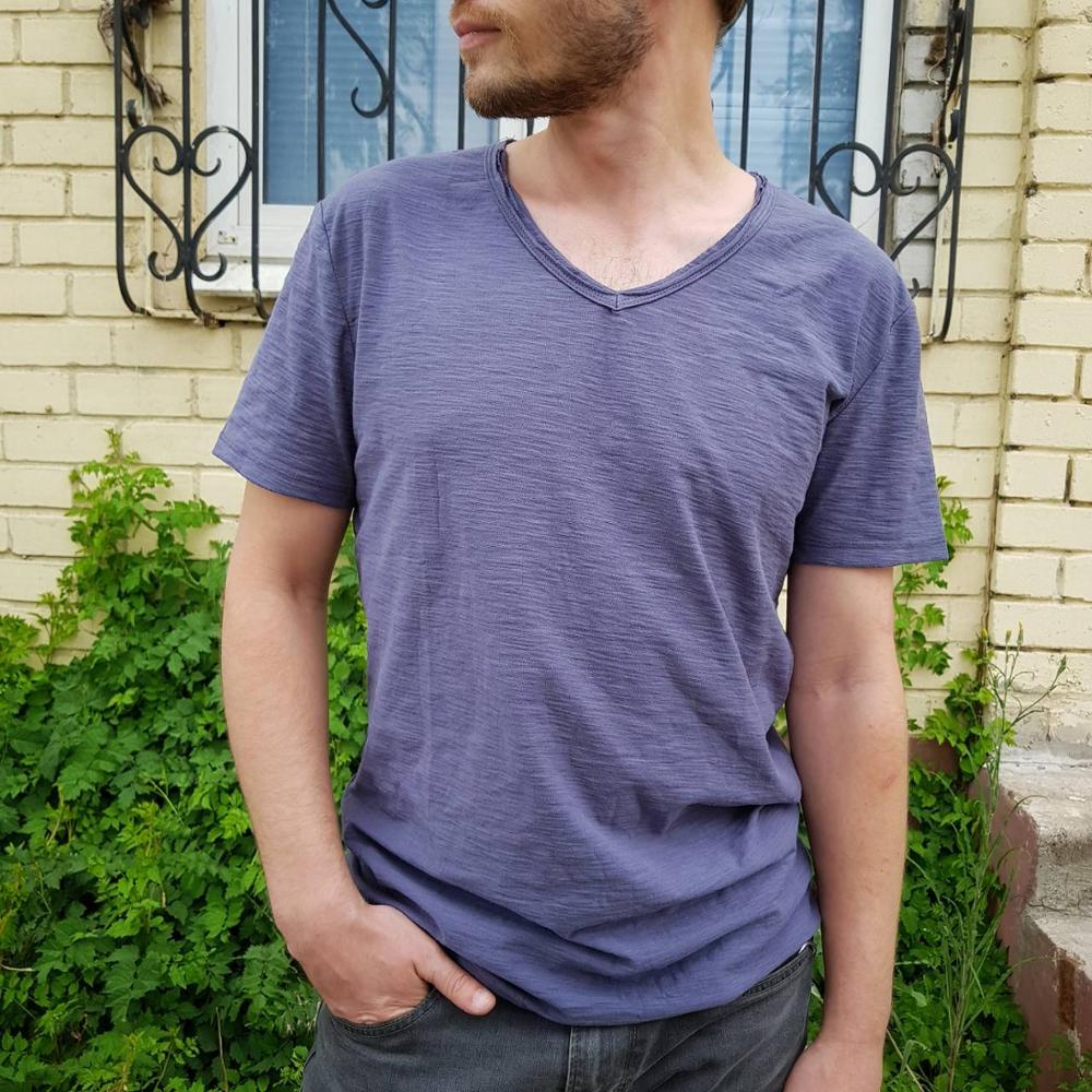 Produktvisning av en sammenbrettet V-genser i linblanding for menn, klar for reise