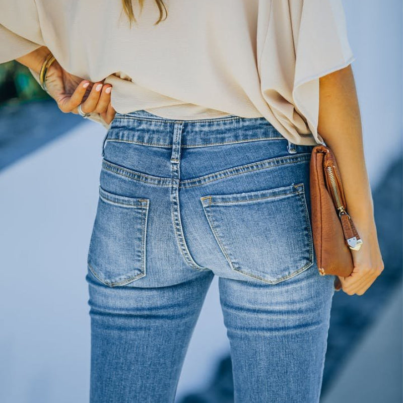 "Høytlivs, flared 70-talls jeans for damer i medium vask, med retro stil og moderne passform."