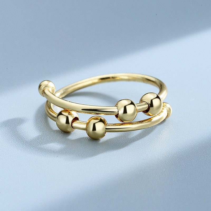 Hånd iført en justerbar fidget-ring for kvinner, smykke for stressmestring og fokus i hverdagen
