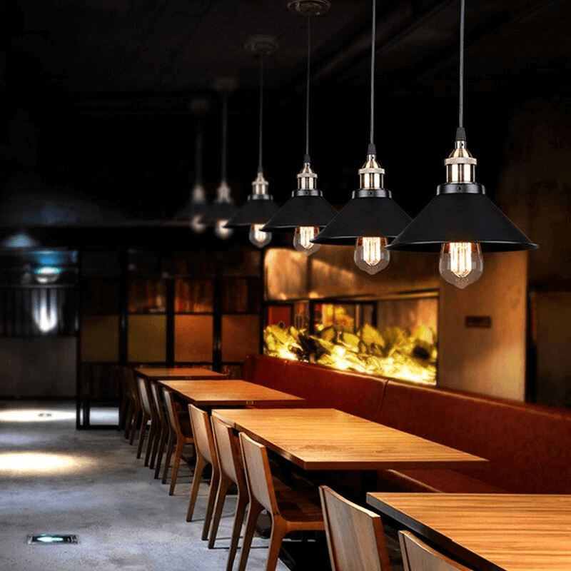 Kjegleformet pendellampe i antikk messing med svart aksent, vintage industridesign, justerbar kabel for stilfull belysning.