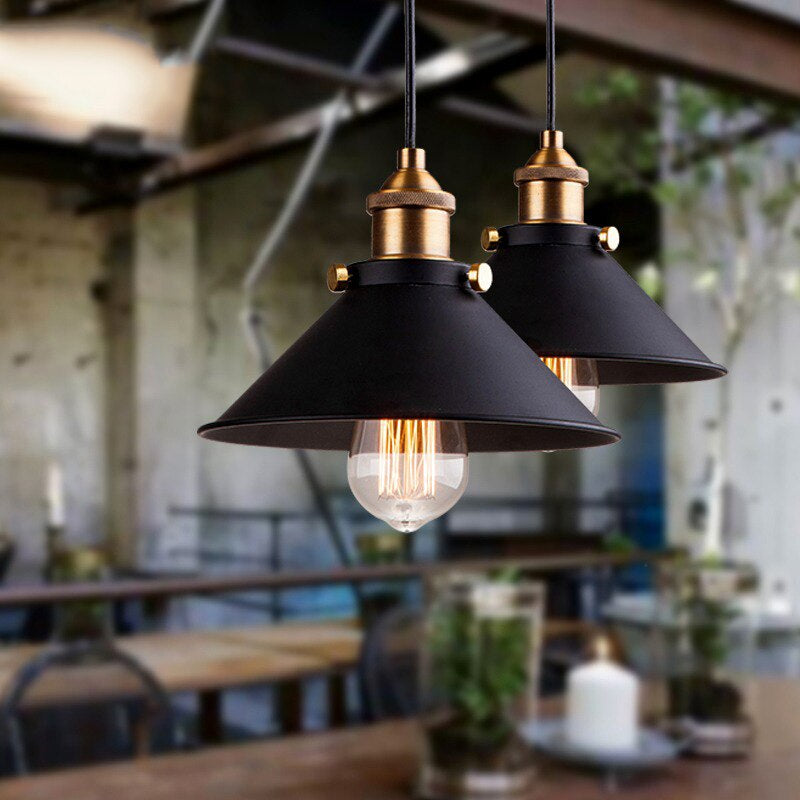 Kjegleformet pendellampe i antikk messing med svart aksent, vintage industridesign, justerbar kabel for stilfull belysning.