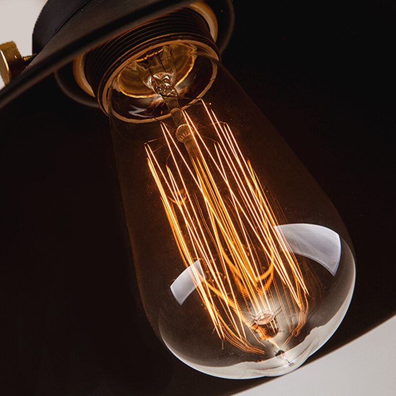 Kjegleformet pendellampe i antikk messing med svart aksent, vintage industridesign, justerbar kabel for stilfull belysning.
