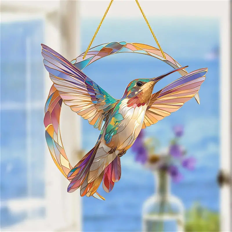 Detalj av hengende kolibri solfanger, krystaller fanger lys i lilla toner.