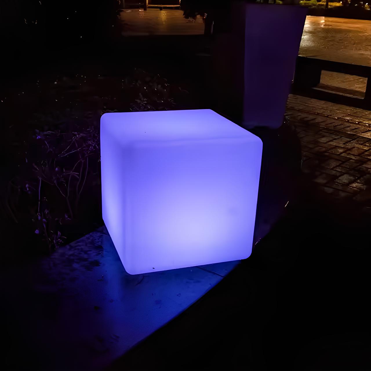 Stemningsfullt flerfarget LED-lys. Kubeformet utendørslampe skaper atmosfære i hagen.