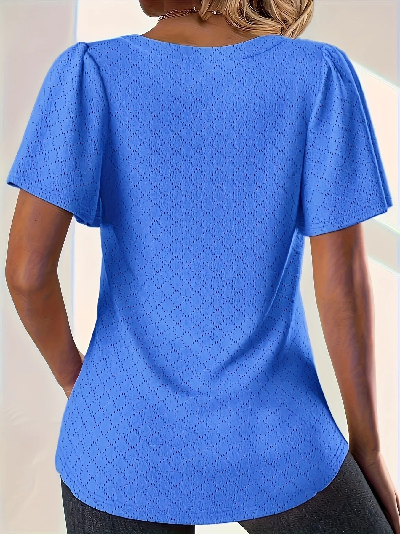 Elegant volangtopp for kvinner med utskårne detaljer, perfekt for casual sommer eller kontorstil.