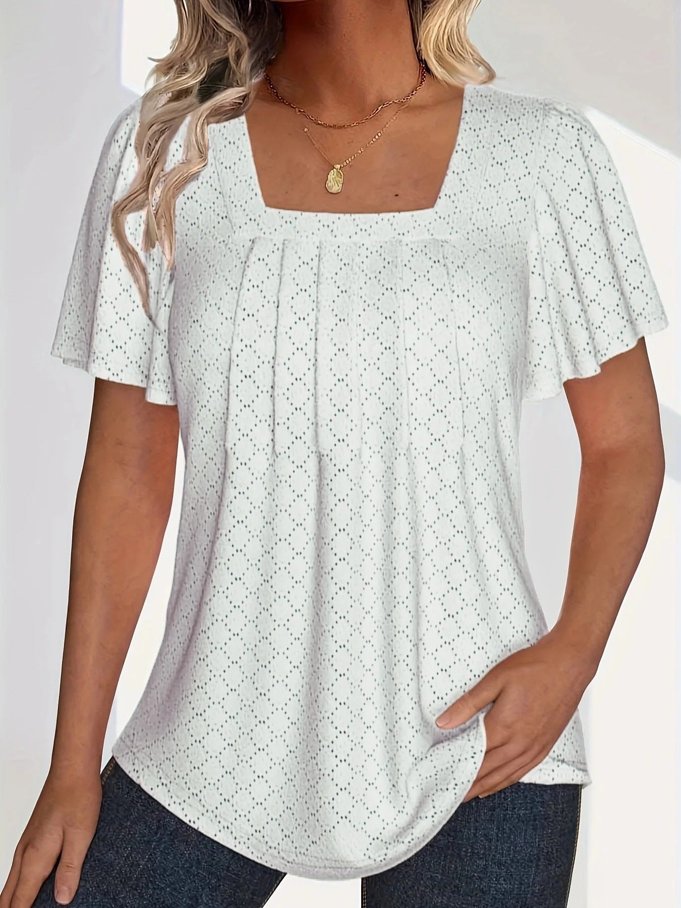 Trendy kvinnetopp med volanger og utskjæringer; ideell for en elegant og komfortabel sommerstil.