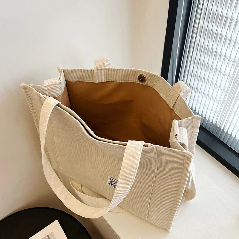 Detaljebilde av teksturen på en kvinners kordfløyel håndveske, casual