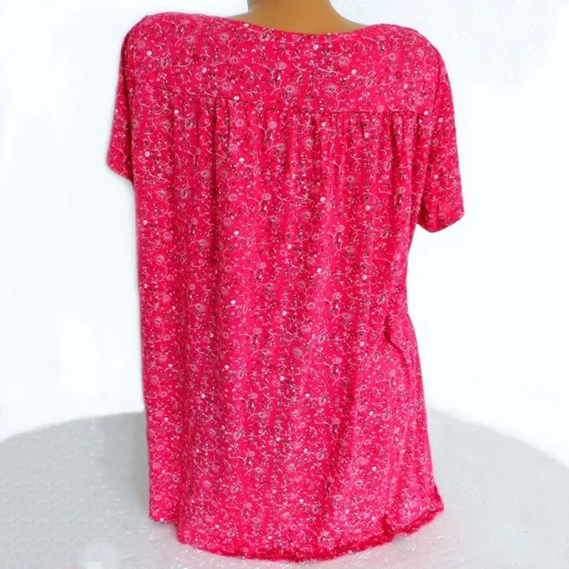 Feminin sommer tanktopp med V-hals og sjarmerende blomstertrykk. Løs og behagelig passform.