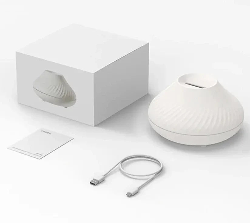 LED luftfukter med vulkanflamme på et bord, skaper en rolig oase med fuktighet og lys i stuen eller soverommet.