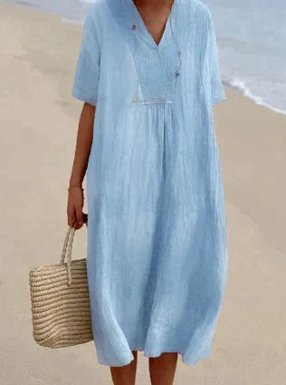 Lett sommerkjole i linblanding med V-hals og knelang lengde for en feminin, elegant og komfortabel stil. Perfekt til varme da