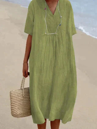 Lett sommerkjole i linblanding med V-hals og knelang lengde for en feminin, elegant og komfortabel stil. Perfekt til varme da
