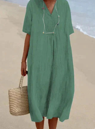 Lett sommerkjole i linblanding med V-hals og knelang lengde for en feminin, elegant og komfortabel stil. Perfekt til varme da