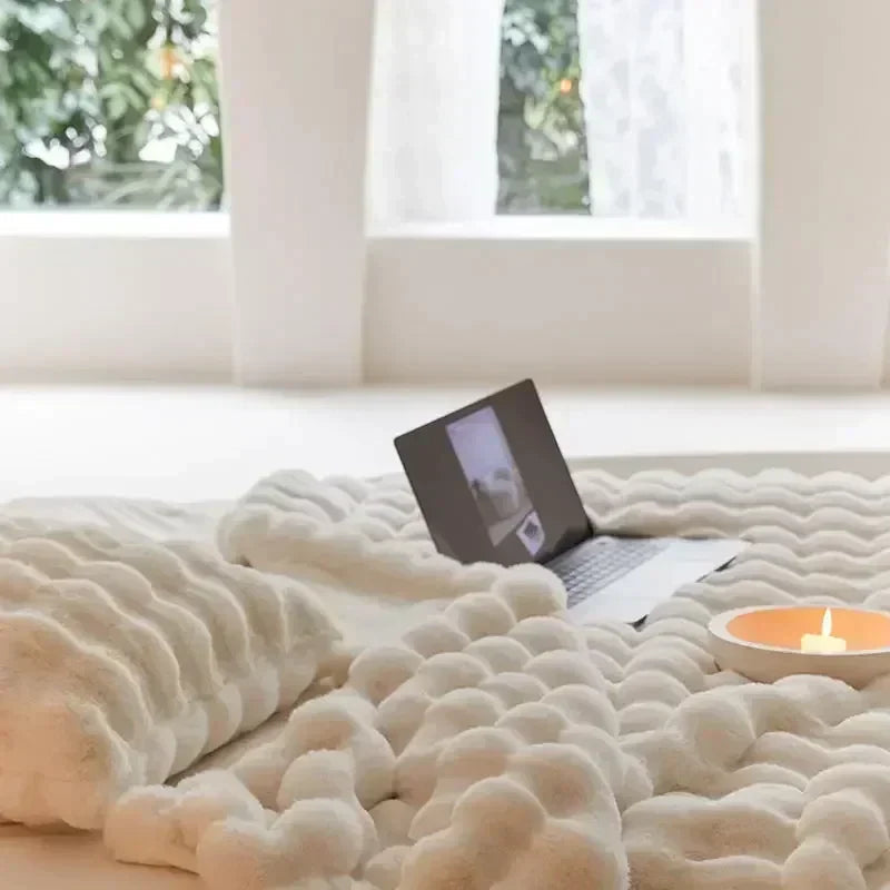 Fuskepelsteppe elegant drapert over en sofa, fungerer som et varmt pelspledd for kos og stil.