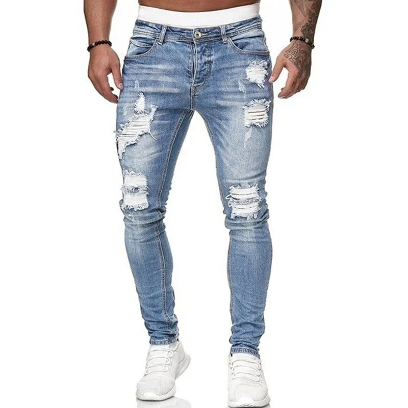 Nærbilde av de rippede detaljene på komfortable menns skinny jeans i denimstoff.