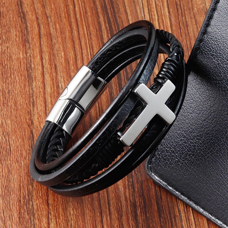 Religiøst armbånd for menn; flettet skinn med polert stålkors og sikker magnetlås.