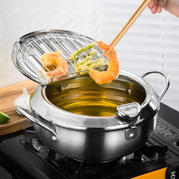 Sprø kyllingvinger lages i en kraftig frityrkoker i rustfritt stål, ideell for perfekt stekt mat hjemme.