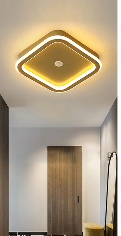 "Moderne LED-taklampe i metall med bevegelsessensor, energieffektiv, i svart og gull, stilrent design."
